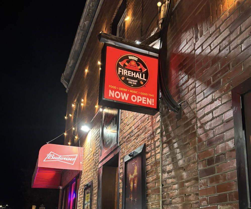Madoc Firehall Food Fun & Friends Restaurant. A red sign can be seen outside of a brick building with the words Firehall on them.